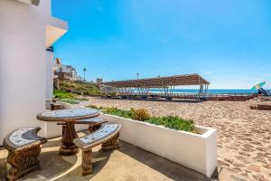 a patio with benches and tables on the beach at Villa Querubines 53 - Playa Arcangel in Rosarito