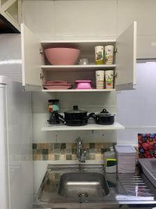 uma cozinha com um lavatório e uma prateleira com panelas e frigideiras em 42 LOFT DUPLO · LOFT perto do Aeroporto de Congonhas e Zoológico em São Paulo