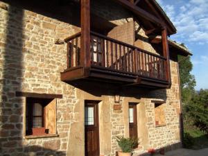 a stone building with a wooden balcony on it at Los Cascayos in Abantro