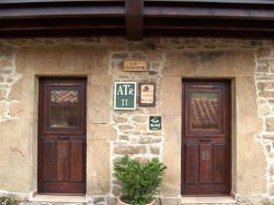 un edificio de piedra con dos puertas. en Los Cascayos en Abantro