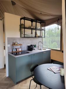 eine Küche mit einem Waschbecken und einem Tisch in einem Zelt in der Unterkunft Mooidal Boutique Park Glamping in Meerssen