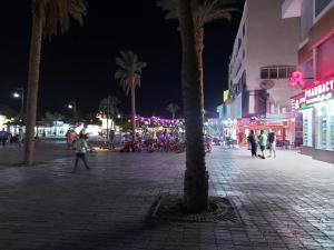 a city street at night with people walking around at Horizon on Mamsha 2 in Hurghada