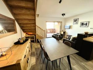 a kitchen and living room with a table and chairs at Résidence Res Cristal - 3 Pièces pour 4 Personnes 721 in Notre-Dame-de-Bellecombe