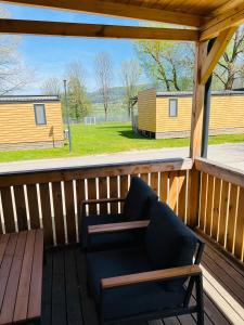 a wooden porch with a bench and a table at Nord mobile house in Velenje