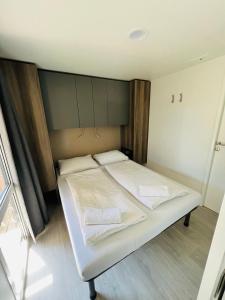 Bett in einem Zimmer mit zwei Kissen darauf in der Unterkunft Nord mobile house in Velenje