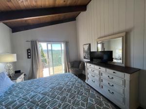 a bedroom with a bed and a dresser with a mirror at Lakeview Ridge+ lake view + Balcony’s + Game Room in Lake Arrowhead