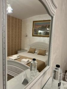 een spiegelbeeld van een slaapkamer met een bed bij Carpentiere Arena in Răşinari