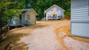 a dirt road between two houses and a house at Lakeshore Fishing Cabin 5, dock, boat slip and firepit area in Lake Ozark
