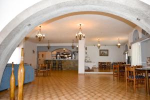 an archway in a room with tables and chairs at Anamar Patmos in Skala
