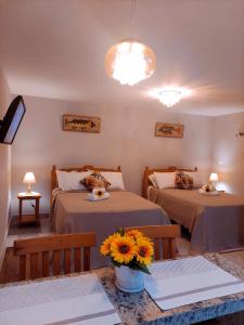 a room with two beds and a vase of flowers at Meu Cantinho Familiar in Búzios
