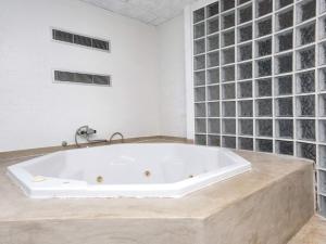 a white bath tub in a bathroom with glass walls at 10 person holiday home in Glesborg in Fjellerup Strand