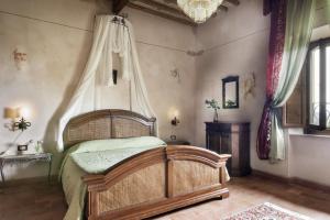 1 dormitorio con cama de madera y dosel en Agriturismo Il Palazzino en Bibbona