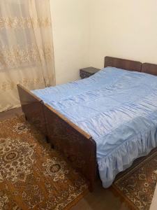 a bed in a bedroom with a blue blanket on it at Ashatark private cosy home in Aghtsʼkʼ