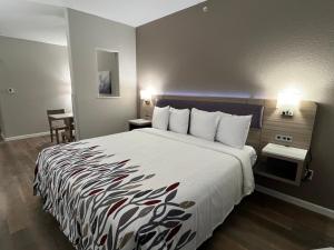 a hotel room with a large bed and a table at Red Roof PLUS San Antonio Northeast in San Antonio