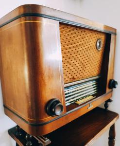 an old radio sitting on a wooden stand at Varanda do Outeiro in Melgaço