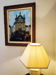 a lamp and a picture of a clock tower on a wall at Varanda do Outeiro in Melgaço