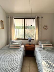 two twin beds in a bedroom with a window at Pura Armonia Condo With Outdoor Patio in Coco +44 photos