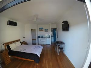 a bedroom with a bed and a table and a kitchen at On the Deck @ Shark Bay in Denham