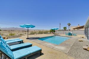 a swimming pool with two lounge chairs and an umbrella at Lake Havasu City Home 4 Mi to London Bridge Beach in Lake Havasu City