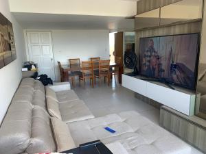 salon z kanapą i telewizorem w obiekcie Apartamento 3 quartos equipado w mieście Maceió