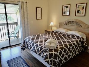 a bedroom with a bed with a black and white comforter at 203D GBR Beautifully Remodeled 4 Bed 3 Bath in Surfside in Myrtle Beach