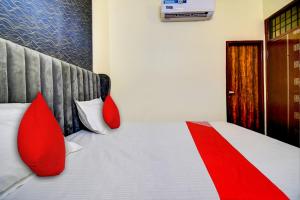 a bedroom with a bed with red pillows on it at Flagship Hotel White Hut in Delhi