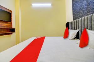 a hotel room with a bed with red pillows at Flagship Hotel White Hut in Delhi