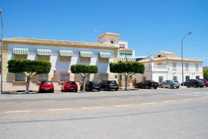 a large building with cars parked in a parking lot at Hotel Mi Casa in Antas