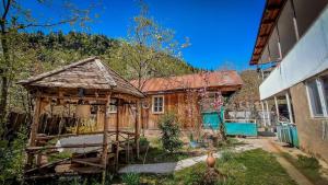 a wooden house with a gazebo in a yard at Guest House "SVANETI" in Lentekhi