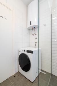 a washing machine in a bathroom with a glass door at Luxury with jacuzzy on a private roof terrace in Nin