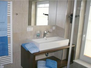 a bathroom with a white sink and a mirror at Ostseebrandung - Haus Seestern in Dranske