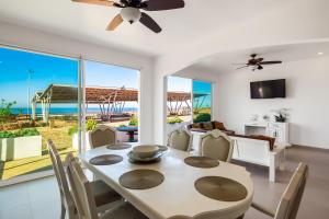 a dining room with a table and chairs with a view of the ocean at Villa Dorado 57 - Playa Arcangel in Rosarito