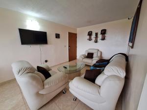 a living room with two couches and a tv at Apartamento full equipado en Lechería in El Morro de Barcelona