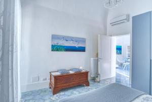 a white room with a bed and a table at Devalù casa del mare in Cefalù