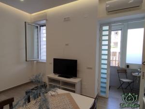a living room with a television and a table at Al GeChiGiù in Bacoli +12 photos
