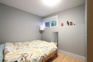 1 dormitorio con cama y ventana en 2 bdr QE/Riley Park Cambie/Main by Canada Line, en Vancouver