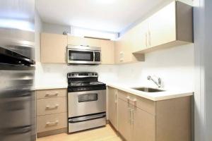 a small kitchen with a stove and a microwave at 2 bdr QE/Riley Park Cambie/Main by Canada Line in Vancouver