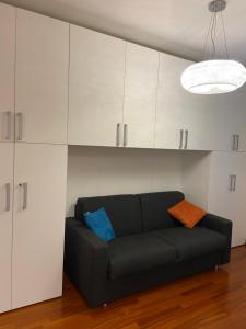 a black couch in a living room with white cabinets at Pool Apartment Bellagio in Bellagio