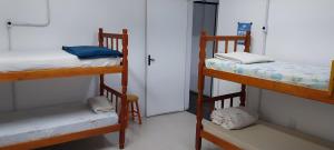 a room with two bunk beds and a door at Aloha Hostel&CoWorking - Prox Aeroporto e Consulado in Porto Alegre