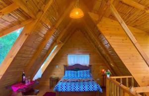 a bedroom with a bed in a wooden attic at Cabaña Mafer in Guatavita