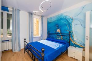 - une chambre bleue avec un lit orné d'une peinture murale dans l'établissement Bianca Azzurra, à Finale Ligure