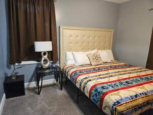 1 dormitorio con 1 cama con una manta colorida y una lámpara en Large, Fenced, Near Beale Street Downtown, Hot tub, en Memphis