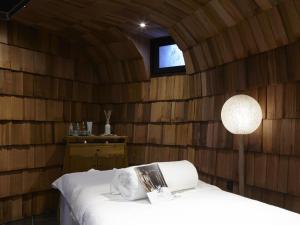 a room with a bed in a wooden wall at Hôtel des Dromonts by SOWELL COLLECTION in Avoriaz