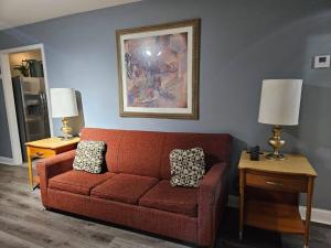sala de estar con sofá rojo y 2 lámparas en Large, Fenced, Near Beale Street Downtown, Hot tub, en Memphis
