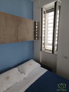 a bed in a room with a window at Al GeChiGiù in Bacoli