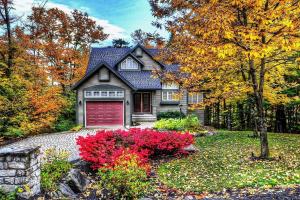 a house with a red garage in the yard at Chalet 28 Chemin des Skieurs in Stoneham
