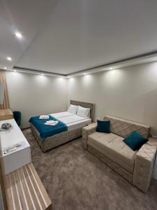 ein Wohnzimmer mit einem Bett und einem Sofa in der Unterkunft Center Deluxe Garni Hotel in Niš