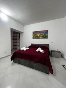 um quarto com uma cama grande e um cobertor vermelho em Casa vacanze La Bonta' di Palermo em Palermo