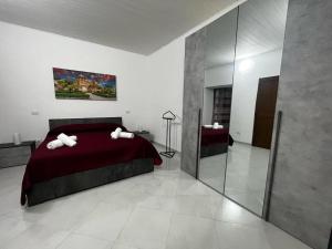um quarto com uma cama vermelha e um espelho em Casa vacanze La Bonta' di Palermo em Palermo