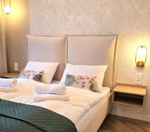 a bedroom with two beds with white sheets and pillows at Apartament Cudny Widok z Sauną - KRAS RESORT in Szklarska Poręba